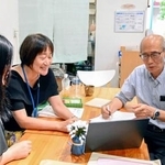 　韓国文化を学ぶ地域クラブ発足に向けてスタッフと打ち合わせをする金シニョンさん（右）＝８月、神戸市長田区