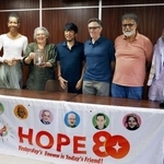 　記者会見を終え、記念撮影に応じる東条英利さん（左から３人目）、クリフトン・トルーマンさん（同４人目）ら＝２２日午後、京都市左京区
