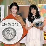 　交換したプレゼントを手に写真に納まる高石あかりさん（左）と今田美桜さん＝２３日午後、大阪市中央区のＮＨＫ大阪放送局