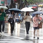 　台風１８号の影響で雨が降る中、歩く人たち＝２３日、台北（ＡＰ＝共同）