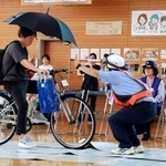 　交通安全教室で、傘を差しての運転を実演する熊本県警の職員＝２５日午後、熊本県菊池市