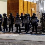 　トランプ大統領の移民政策に抗議するデモの警備に当たるＩＣＥ施設の職員＝９月１日、ポートランド（ロイター＝共同）
