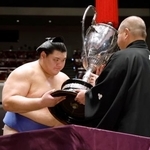 　大相撲秋場所で、横綱として初となる優勝を果たし、日本相撲協会の八角理事長（右）から賜杯を受け取る大の里＝２８日、東京・両国国技館