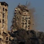 　２８日、イスラエル軍のミサイル攻撃を受け倒壊するガザ市のビル（ゲッティ＝共同）