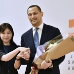 　退任に当たり、職員から花束を受け取るスポーツ庁の室伏広治長官（右）＝３０日午後、東京・霞が関