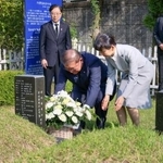 　ＪＲ新大久保駅転落事故で亡くなった韓国人留学生の李秀賢さんの墓地を参拝し、献花する石破首相。右は妻の佳子さん＝３０日、韓国・釜山（内閣広報室提供・共同）