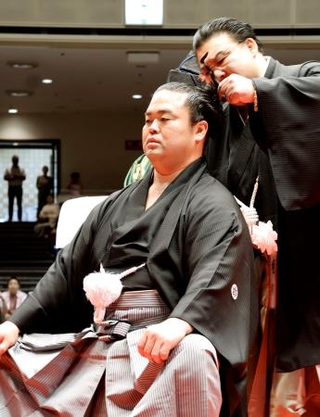 　引退相撲の断髪式で師匠の境川親方に最後のはさみを入れられる元関脇妙義龍の振分親方＝５日、両国国技館