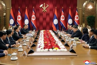 　ラオスのトンルン国家主席（左から４人目）と会談する北朝鮮の金正恩朝鮮労働党総書記（右から４人目）＝７日、平壌（朝鮮中央通信＝共同）