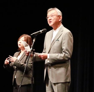 　山形国際ドキュメンタリー映画祭の開会式であいさつするＮＰＯ法人の加藤到理事長（右）＝９日午後、山形市