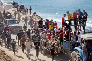 　停戦を受け、避難先のガザ南部から北部に戻る人たち＝１０日、ガザ中部（ロイター＝共同）