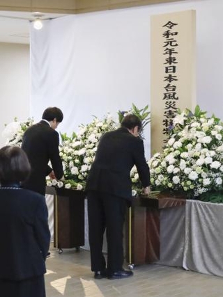 　台風１９号上陸から６年となり、宮城県丸森町に設けられた献花台に花を供える参列者＝１２日午前