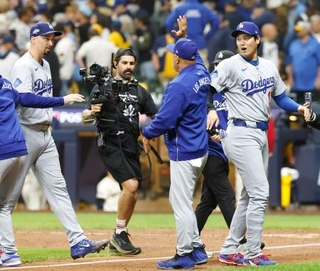 　ブルワーズに勝利し、ロバーツ監督とタッチを交わすドジャース・大谷（右）＝ミルウォーキー（共同）