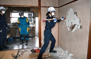 　訓練で岐阜羽島署の旧署長官舎の土壁を壊す警察官＝１５日午前、岐阜市