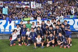 　ブラジルから初勝利を挙げ、サポーターと写真に納まる日本代表＝１４日、味の素スタジアム
