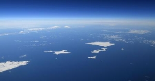 　北海道・根室半島の納沙布岬（左下）沖に広がる北方領土。歯舞群島（中央）、色丹島（右上）、国後島（左奥）。はるか右奥にうっすらと択捉島が見える