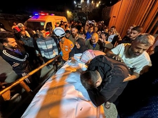 　２８日、パレスチナ自治区ガザ南部ハンユニスの病院で、イスラム組織ハマスの空爆で死亡した人のそばに集まる人々（ロイター＝共同）