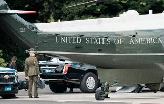 　トランプ米大統領を乗せた大統領専用ヘリ、マリーンワンのそばで「核のボタン」とみられるかばんを持ち待機する米軍関係者＝２９日午前、東京都港区の赤坂プレスセンター