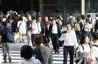 　東京・丸の内を行き交う人たち＝７月