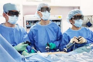 　胸に開けた小さな穴から器具を入れる胸腔鏡手術の様子。モニター画面を見ながら行う（浜松医科大提供）