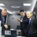 　ウクライナ・キーウで、寄贈した車両について話す中込正志大使（右）ら＝９月３０日（共同）