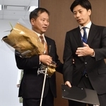 　職員（右）の介助を受けながら初登庁した、パラ選手から初のスポーツ庁長官となった河合純一氏＝１日午前、東京・霞が関