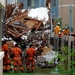 　木造２階建ての住宅が倒壊した現場で作業をする消防隊員ら＝１日午前８時３４分、東京都杉並区