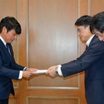 　佐賀県議会議長（左）に要望書を提出する県弁護士会の半田望弁護士（右手前）ら＝１日午前、佐賀市