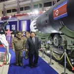 　最新兵器を並べた「武装装備展示会」に臨む北朝鮮の金正恩朝鮮労働党総書記（手前右）＝４日、平壌（朝鮮中央通信＝共同）