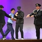 　特殊詐欺の犯人役（左から３人目）をヨーヨーの糸を使って取り押さえるパフォーマーら＝５日午後、東京都昭島市