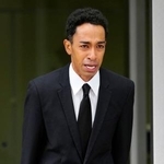 　釈放され、警視庁三田署前で一礼する草間リチャード敬太さん＝６日午後２時２１分