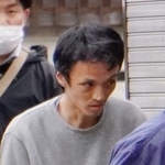 　家宅捜索に立ち会うため、捜査員に連れられて自宅マンションに入る桑野浩太容疑者＝７日午後２時１５分ごろ、東京都町田市