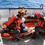 　訓練で、救助対象者に見立てた人形を担架に乗せる機動救難士＝７日午前、北海道羅臼町沖