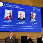 　ノーベル物理学賞を（スクリーン左から）ジョン・クラーク氏、ミシェル・デボレ氏、ジョン・マルティニス氏に授与すると発表した記者会見＝７日、ストックホルム（共同）