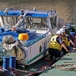 　事故を起こしたとみられる船を調べる海上保安庁の職員ら＝８日午前、東京都中央区