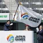 　「わたＳＨＩＧＡ輝く国スポ」の総合閉会式で、滋賀県の三日月大造知事（右）から引き継いだ大会旗を振る次回開催地青森県の宮下宗一郎知事＝８日、平和堂ＨＡＴＯスタジアム