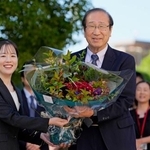 　ノーベル化学賞の受賞決定から一夜明け、職員から花束を受け取る京都大の北川進氏（右）＝９日午前、京都市左京区