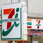 　セブン＆アイ・ホールディングスの看板とコンビニ店舗＝７月、東京都新宿区