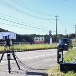 　事故現場付近で速度違反車を監視する警察官＝９日午前、三重県名張市