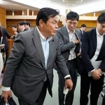 　記者団からの取材を終えて引き揚げる公明党の赤羽一嘉中央幹事会長＝９日夜、東京都新宿区の党本部