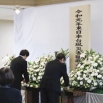 　台風１９号上陸から６年となり、宮城県丸森町に設けられた献花台に花を供える参列者＝１２日午前