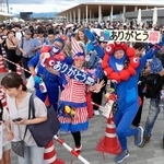 　閉幕日、ミャクミャクをイメージしたファッションで「ありがとう」などのメッセージを掲げる来場者＝１３日午前、大阪市此花区の夢洲