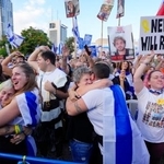 　パレスチナ自治区ガザでイスラム組織ハマスが拘束していた人質の引き渡しが始まったと報じられ、喜ぶ人たち＝１３日、イスラエル中部テルアビブ（共同）