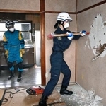 　訓練で岐阜羽島署の旧署長官舎の土壁を壊す警察官＝１５日午前、岐阜市
