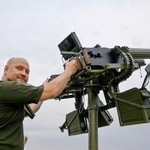 　機関銃を構えるビタリー・ズイエフさん＝７月、キーウ（共同）