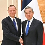 　握手するフランスのボンヌ大統領外交補佐官（左）と中国の王毅外相＝１５日、中国浙江省杭州市（新華社＝共同）