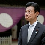 　靖国神社を参拝し、記者団の取材に応じる西村元経産相＝１８日午前、東京・九段北