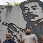 　魯迅の壁画前でたばこを手に記念撮影をする人たち＝９月、中国浙江省紹興市（共同）