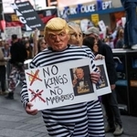 　トランプ大統領の政治手法に抗議するデモで「ＮＯ　ＫＩＮＧＳ（王はいらない）」を掲げる参加者＝１８日、ニューヨーク（ロイター＝共同）