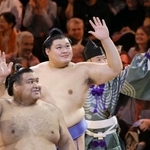 　閉会式を終えて手を振り引き揚げる横綱大の里（中央）ら＝１９日、ロンドン（共同）