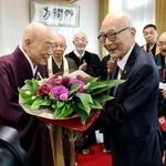 　講演後、清水寺の森清範貫主（左）から花束を受け取る被団協の田中熙巳代表委員＝２０日午後、京都市東山区